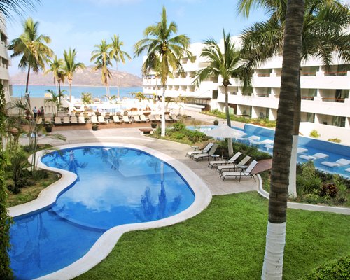 An outdoor swimming pool with chaise lounge chairs.
