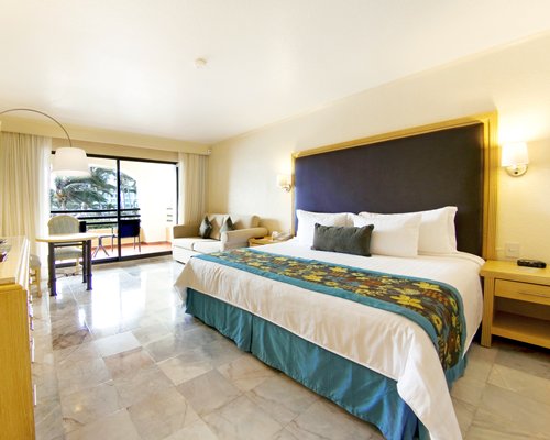 A well furnished bedroom with a balcony and patio furniture.
