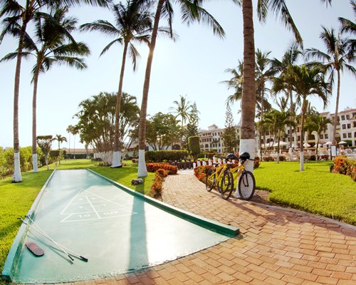 Outdoor recreation area with shuffleboard alongside a pathway with bikes.