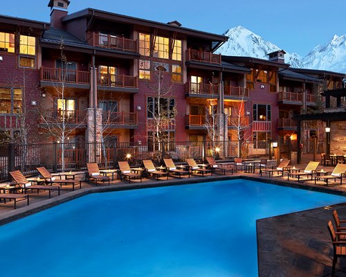 An outdoor swimming pool with chaise lounge chairs.