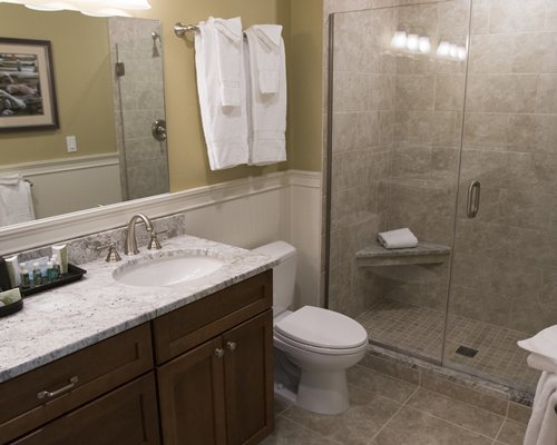 A bathroom with a closed sink vanity and shower stall.
