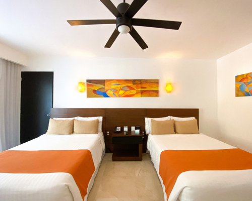 A well furnished bedroom with two beds and a television.