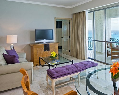 A well furnished living room with a television and the ocean view.