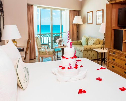 A well furnished bedroom with a television pull out sofa and a balcony.