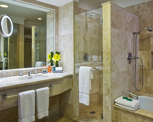 A bathroom with a sink bathtub and shower stall.