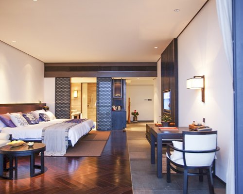 A well furnished bedroom with a king bed and television.