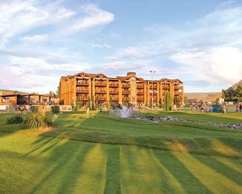 An exterior view of multi story resort units with a well maintained lawn.
