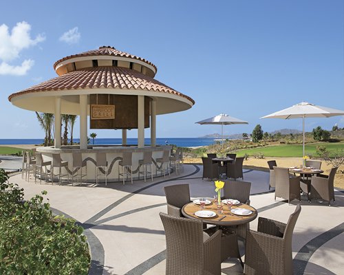 A scenic view of outdoor restaurant alongside the ocean.