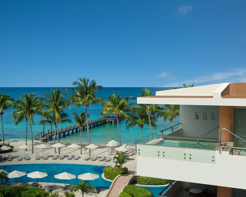 The Secrets Aura Cozumel Resort & Spa with an outdoor swimming pool alongside the ocean.