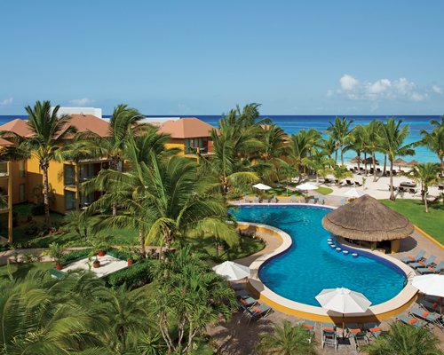 An outdoor swimming pool with a pathway alongside the ocean.