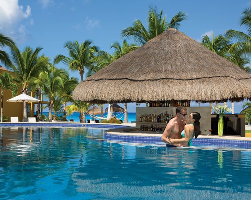 An indoor restaurant with a bar counter at Secrets Aura Cozumel Resort & Spa.