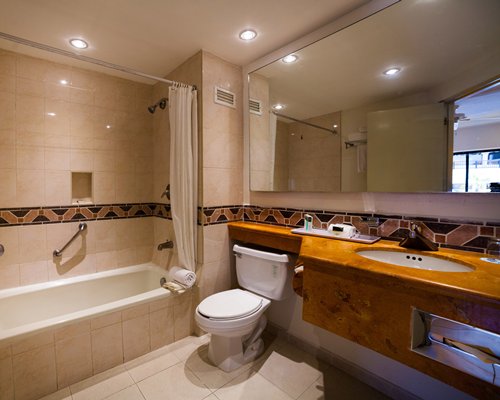 A bathroom with shower bathtub and a single sink vanity.