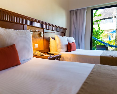 A well furnished bedroom with two double beds.