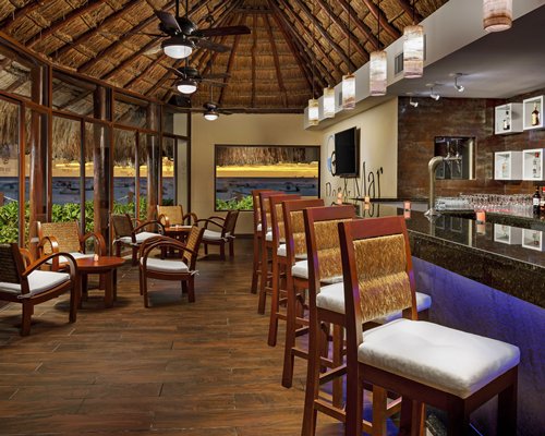 A well equipped indoor bar with a television and outside view.