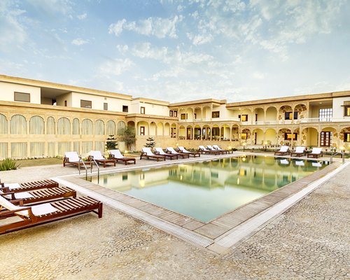 An outdoor swimming pool with chaise lounge chairs.