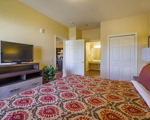 A well furnished bedroom with a king bed and an outside view.