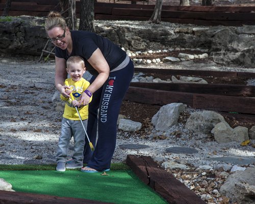 People playing golf at the putt putt golf course.