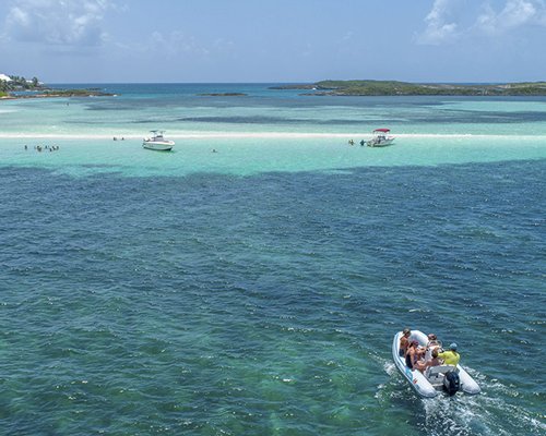 An aerial view of the ocean with multiple sailboats.