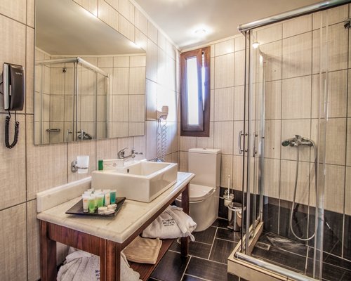 A bathroom with single sink vanity and stand up shower.