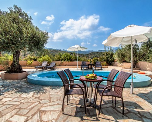 An outdoor swimming pool with chaise lounge chairs and patio furniture.