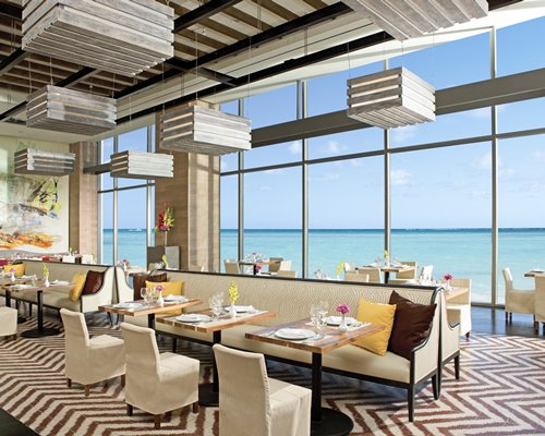 A well furnished indoor restaurant with a view of the sea.
