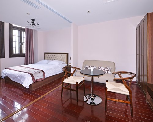 A well furnished bedroom with a two seater dining table.