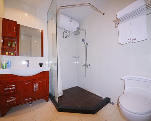 A bathroom with a stand up shower and single sink vanity.