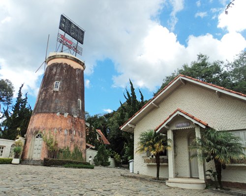 An exterior view of Pousada Do Moinho Velho resort surrounded by trees.
