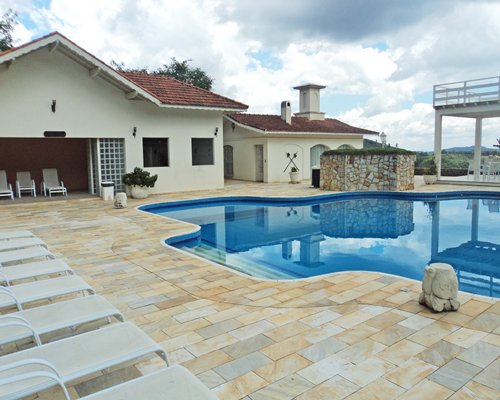 An outdoor swimming pool with chaise lounge chairs.