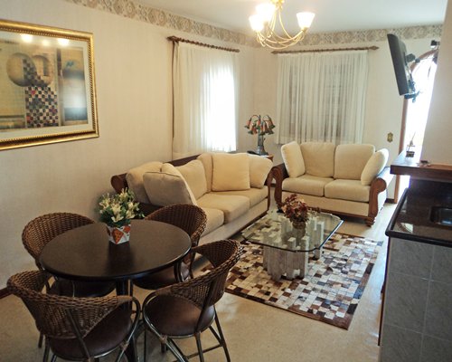 A well furnished living room with a television and dining table.
