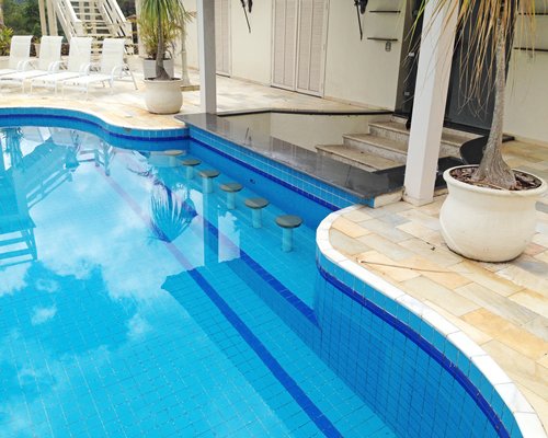 An outdoor swimming pool with chaise lounge chairs.