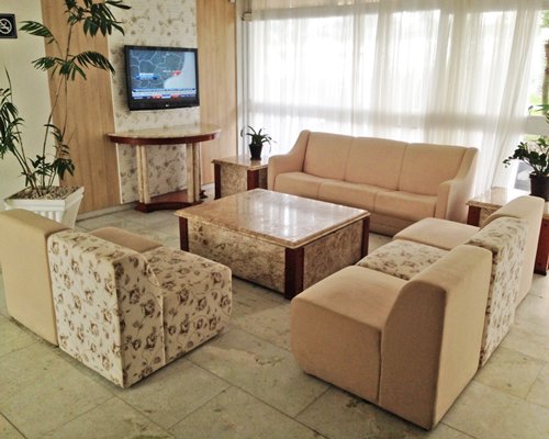 A well furnished living room with a television and potted plants.