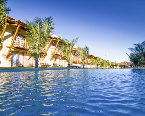 An outdoor swimming pool with trees alongside the resort.