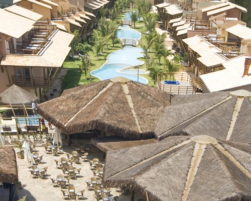 An outdoor dining area alongside the pool and multi story resort units.