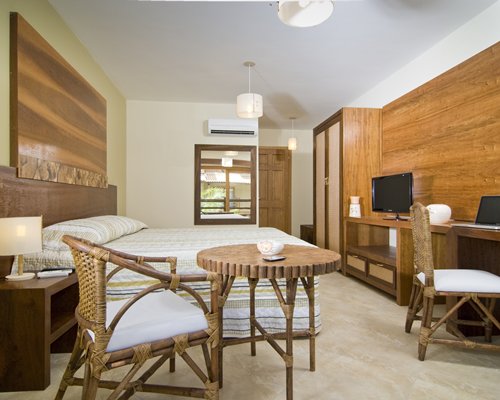 A well furnished bedroom with a television and laptop.