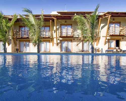 An outdoor pool alongside multi story resort unit.