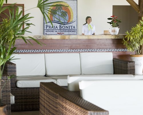 A receptionist at the reception alongside the lounge area at Praia Bonita Resort & Conventions.
