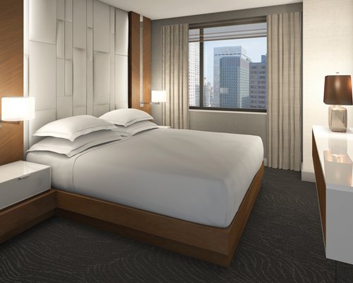 A well furnished bedroom with a king bed and an outside view.