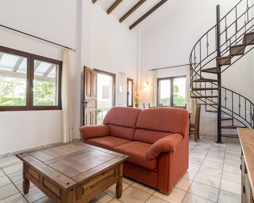 A well furnished living and dining area with a staircase and an outside view.