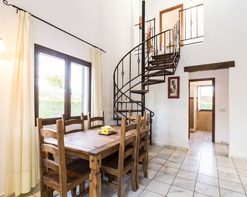 A well furnished dining area with a stairway and an outside view.