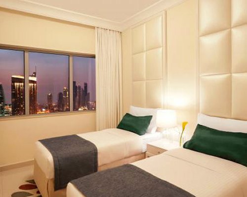 A well furnished bedroom with two beds and outside view.