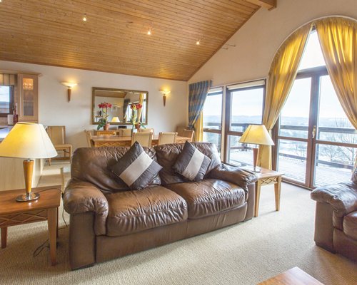 A well furnished living room with a dining area and outside view.