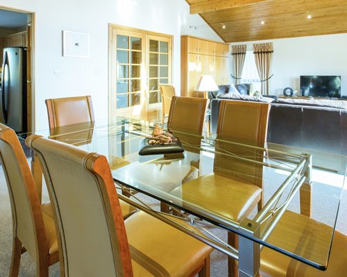 A well furnished dining room with a glass top table.
