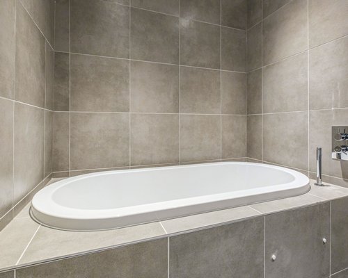 A bathtub set in grey granite tile.