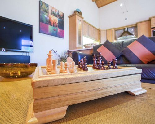A well furnished living room with a television and giant chess board setup.