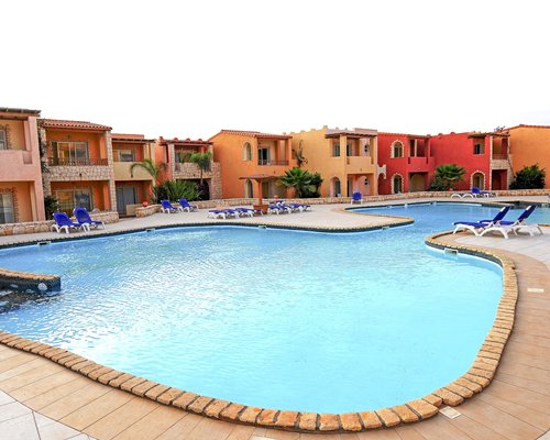 An outdoor pool with chaise lounge chairs alongside the multiple units of the Hotel New Horizons Boa Vista.