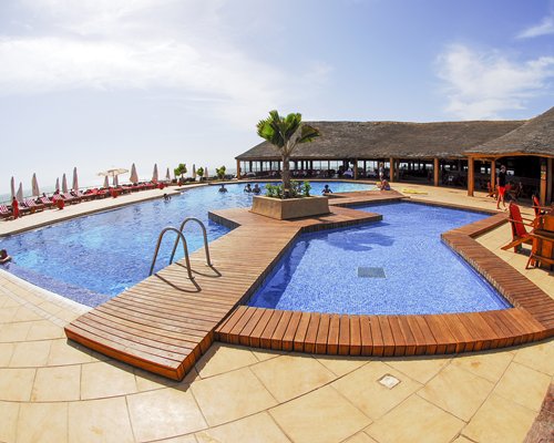 An outdoor swimming pool with chaise lounge chairs.