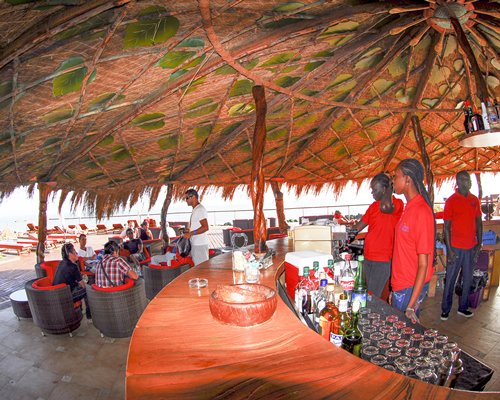 A well equipped an outdoor bar with a thatched roof.