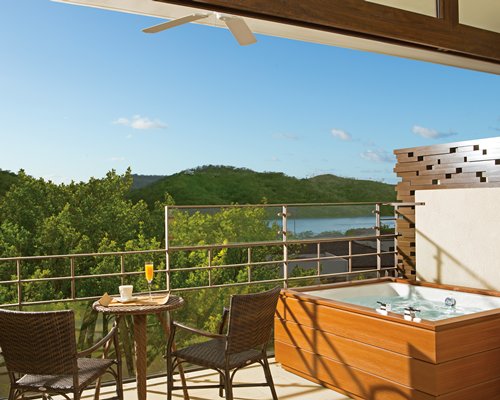 A balcony with patio furniture and a hot tub.