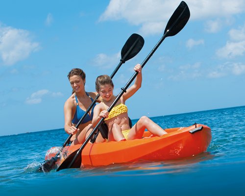 A mother and daughter kayaking at the ocean.